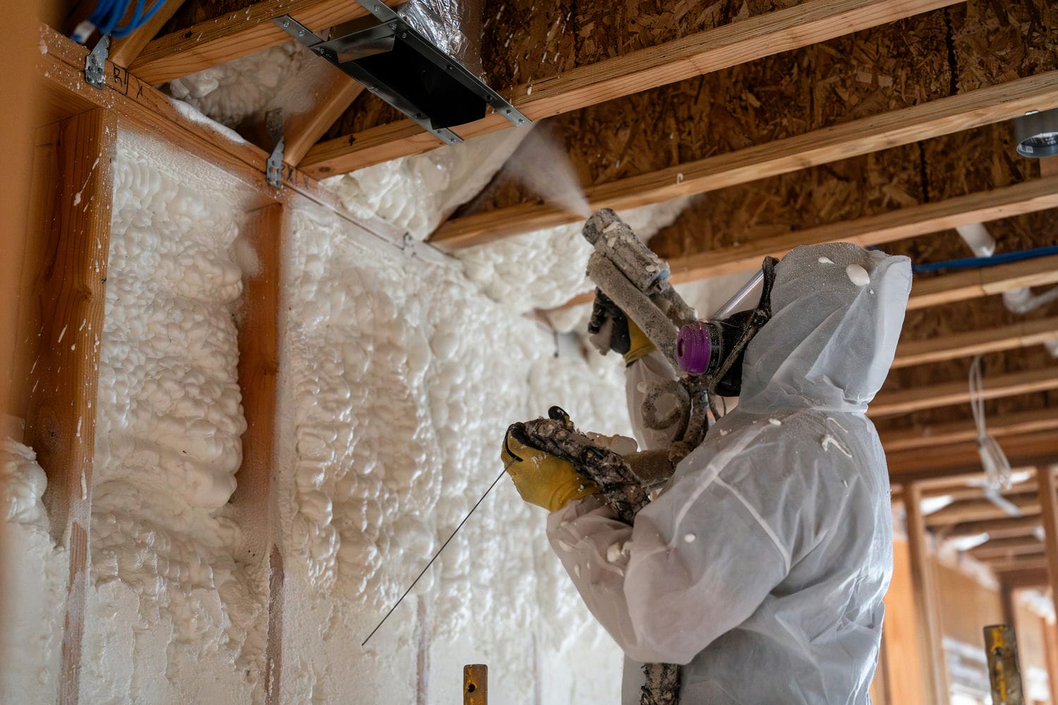 man spraying attic insultation